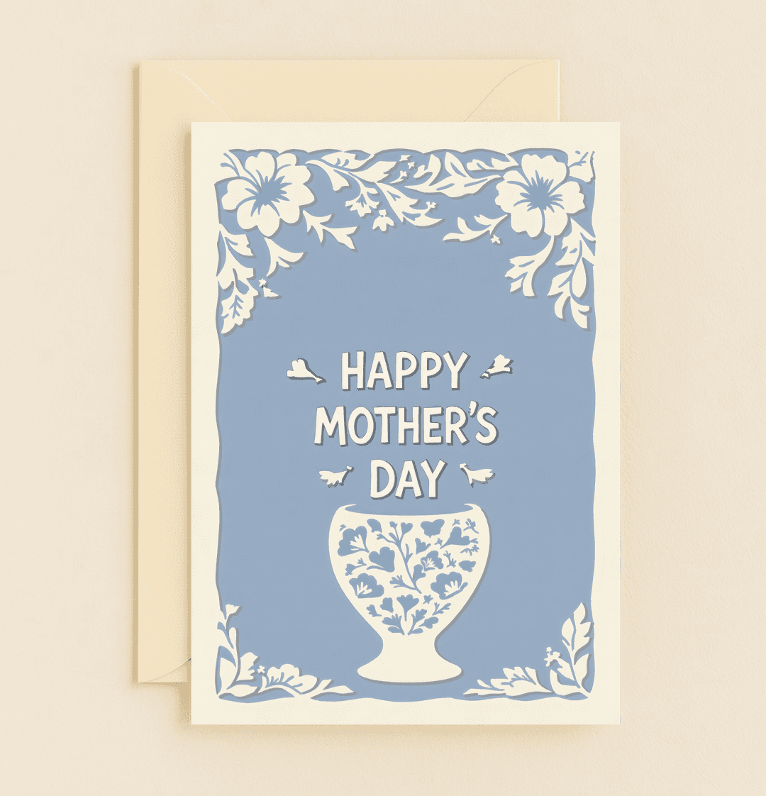 Celebrate Mother's Day with "Floral Elegance," a charming blue and white card adorned with intricate flowers, leaves, and whimsical birds.