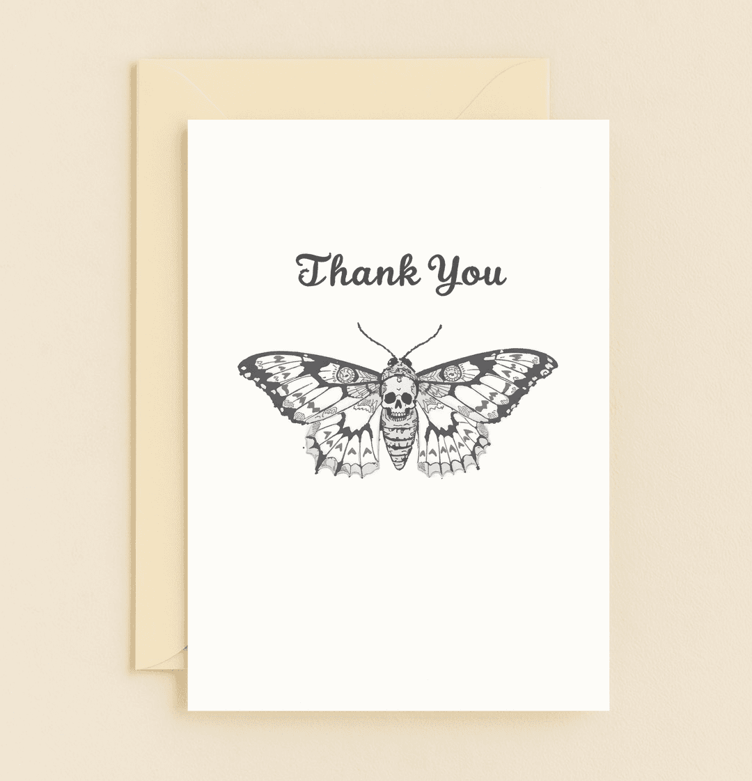 Express your gratitude with a touch of gothic flair through this intricately illustrated black and white card featuring a moth with a subtle skull motif.