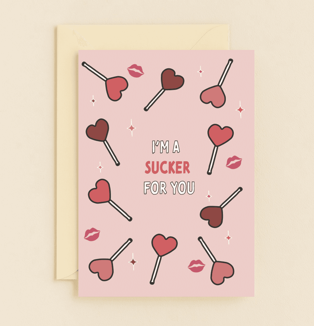 Celebrate Valentine's Day with a playful card featuring heart-shaped lollipops, red lips, and a punny message that says, "I'm a sucker for you!.
