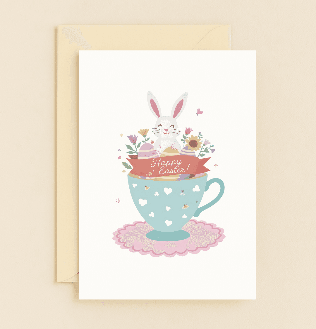 Bring Easter joy with this charming card featuring a playful bunny in a teacup, adorned with flowers, Easter eggs, and a festive "Happy Easter!" ribbon.