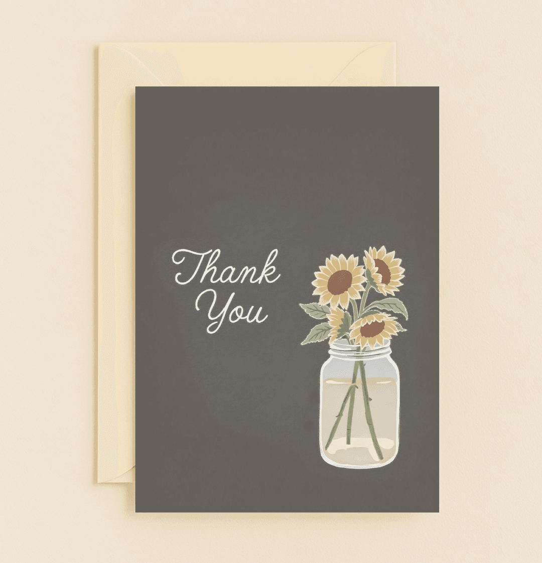 Express heartfelt gratitude with "Sunshine in a Jar: Grateful Blooms," featuring elegant sunflowers in a charming mason jar on a sophisticated gray backdrop.