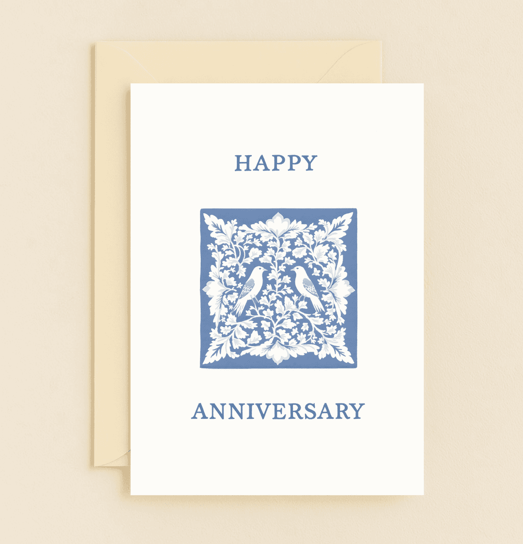 Celebrate your special day with this elegant anniversary card featuring lovebirds and intricate floral patterns in a timeless blue and white design.