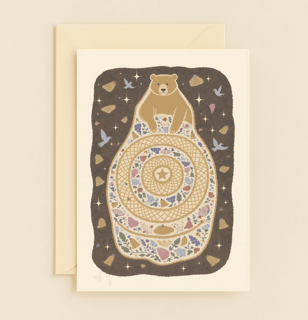 Send a heartfelt Mother's Day hug with this cozy card featuring a bear on a floral quilt, surrounded by stars and tranquil birds.
