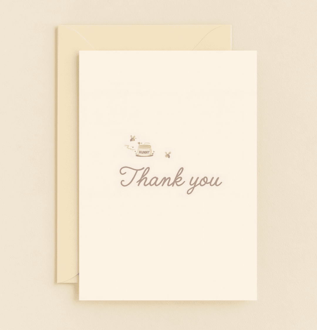 Express gratitude sweetly with this charming card featuring a "HUNNY" pot, buzzing bees, and delicate flowers on a cream background with cursive "Thank you.
