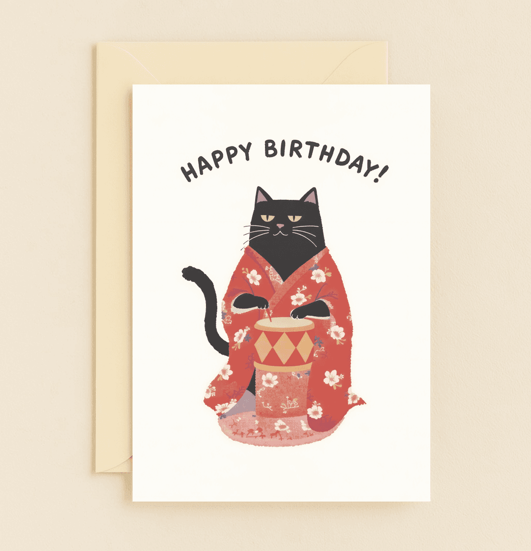 Celebrate a purr-fect birthday with this playful card featuring a cool cat in a kimono, ready to drum up fun with Japanese flair and witty wordplay.