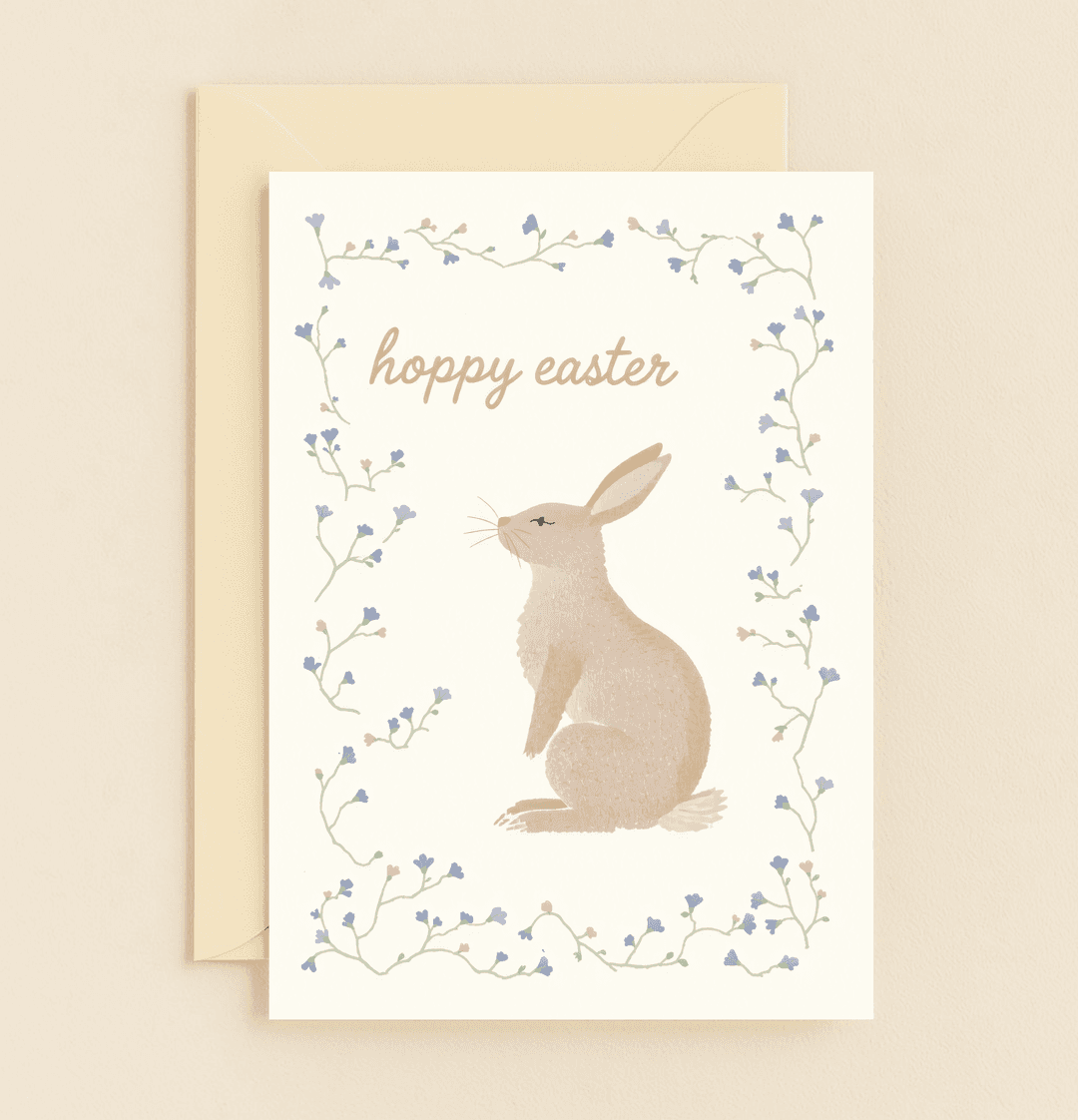 Celebrate Easter with "Bunny Bloom: Hoppy Easter Greetings!"—a whimsical card featuring a charming rabbit amid pastel flowers, perfect for springtime cheer.
