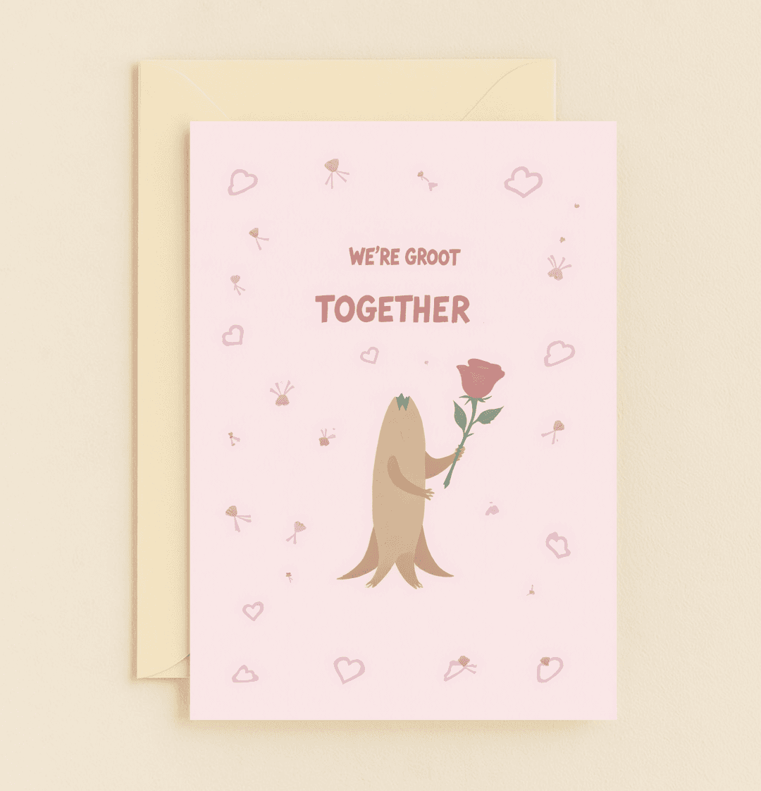 Celebrate your love with this charming anniversary card featuring Baby Groot, a playful pun, and a romantic rose against a heart-strewn pink backdrop.