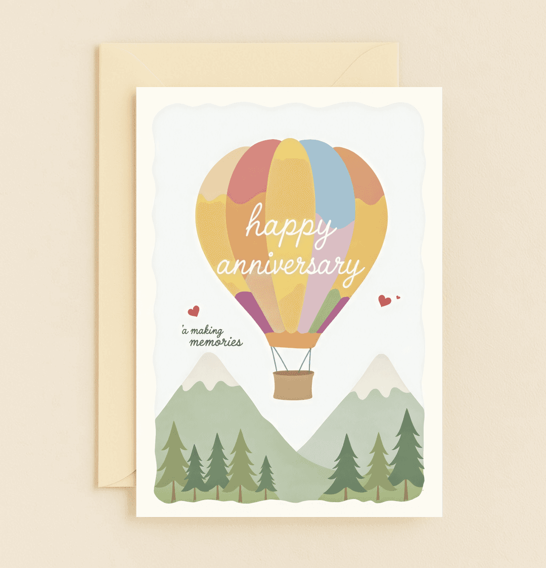 Celebrate your anniversary with a whimsical, colorful card featuring a romantic hot air balloon adventure over mountains, perfect for making memories together.