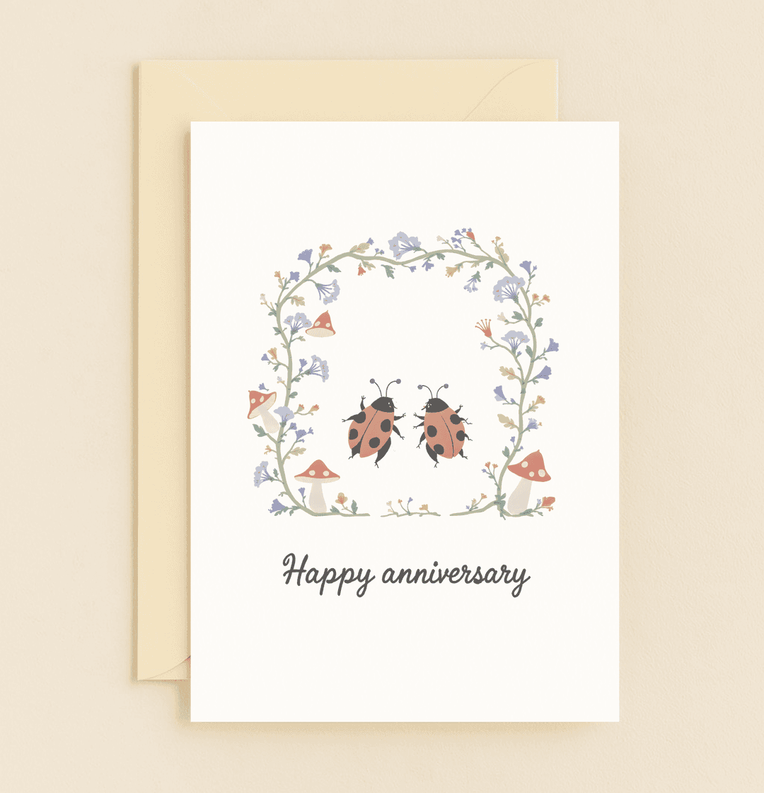 Celebrate your special day with this charming anniversary card featuring cute ladybugs amid whimsical flowers and mushrooms, radiating romance and joy.