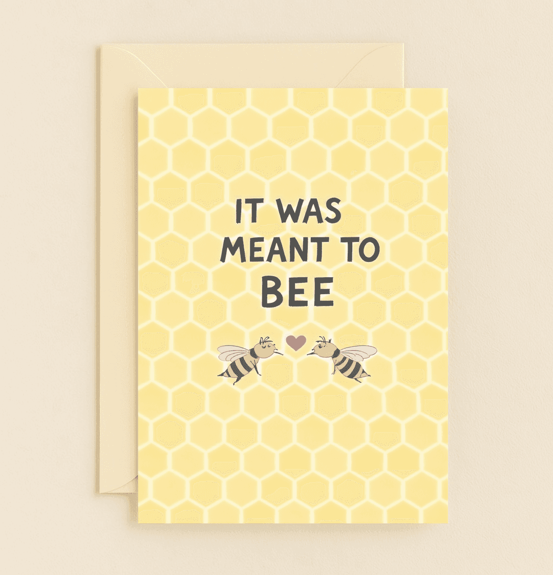 Celebrate your love story with this pun-filled anniversary card featuring a honeycomb backdrop, two sweet bees, and a heartwarming message: "IT WAS MEANT TO BEE.